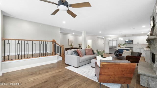 living room featuring ceiling fan and light hardwood / wood-style floors