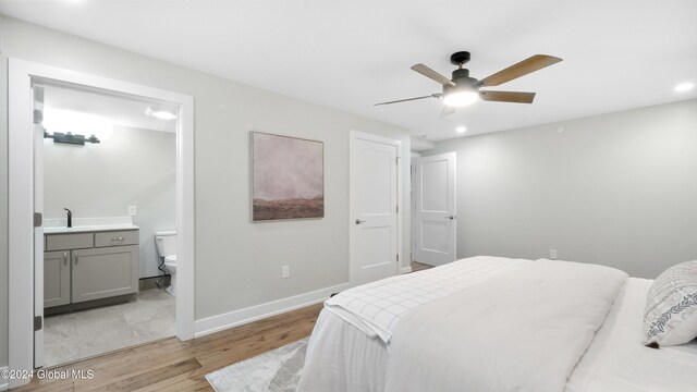 bedroom with ceiling fan, sink, connected bathroom, and light hardwood / wood-style flooring