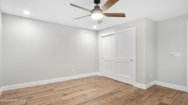 unfurnished bedroom with a closet, light hardwood / wood-style flooring, and ceiling fan