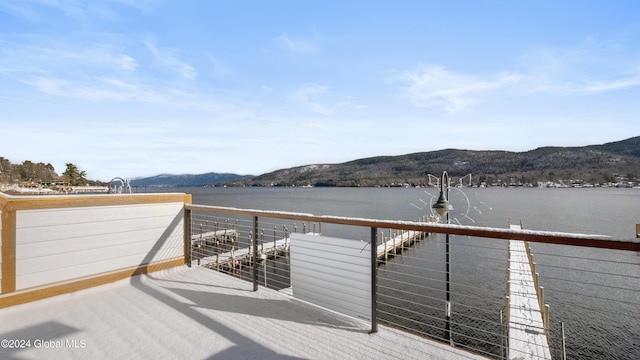 wooden terrace with a water and mountain view