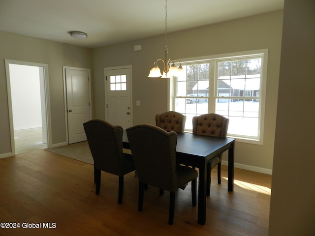 dining area featuring a notable chandelier, plenty of natural light, and wood-type flooring