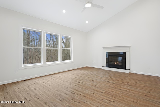 unfurnished living room featuring high vaulted ceiling, ceiling fan, and light hardwood / wood-style floors