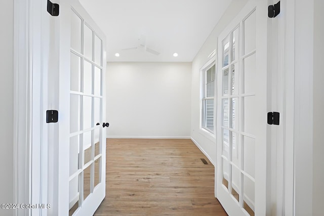 hall featuring french doors and light wood-type flooring