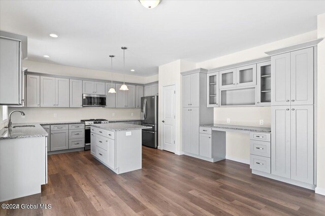 kitchen with a kitchen island, sink, stainless steel appliances, and dark wood-type flooring