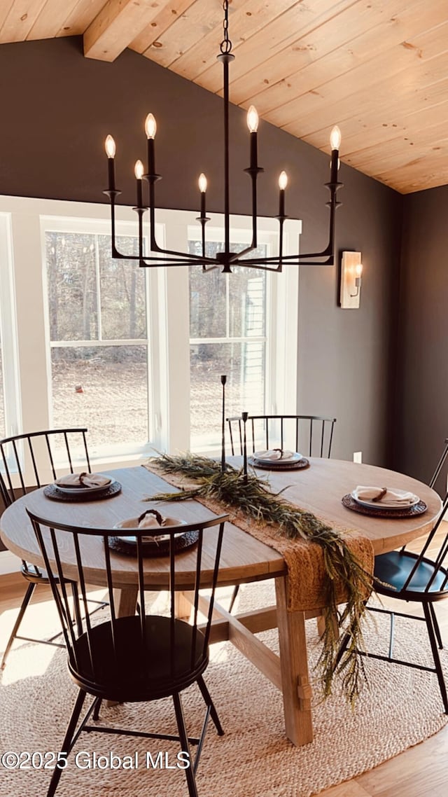 dining space with a chandelier, light hardwood / wood-style floors, lofted ceiling with beams, and wooden ceiling