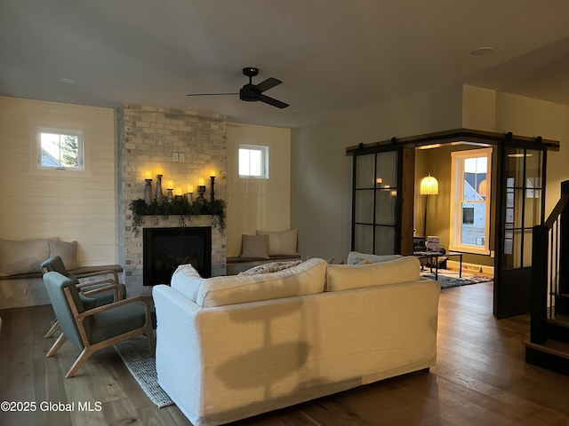 living room featuring hardwood / wood-style flooring, a fireplace, and ceiling fan