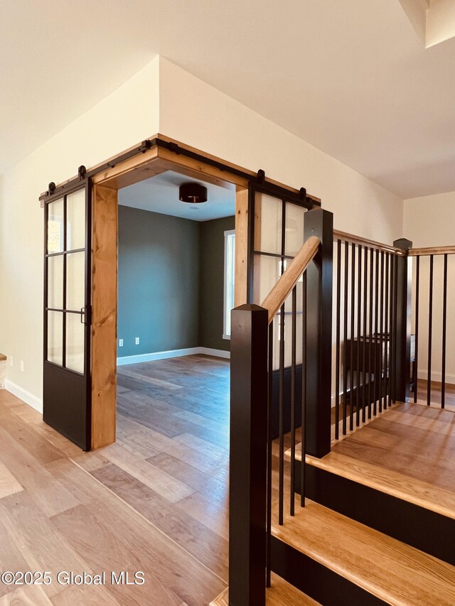 stairway featuring hardwood / wood-style flooring and a barn door