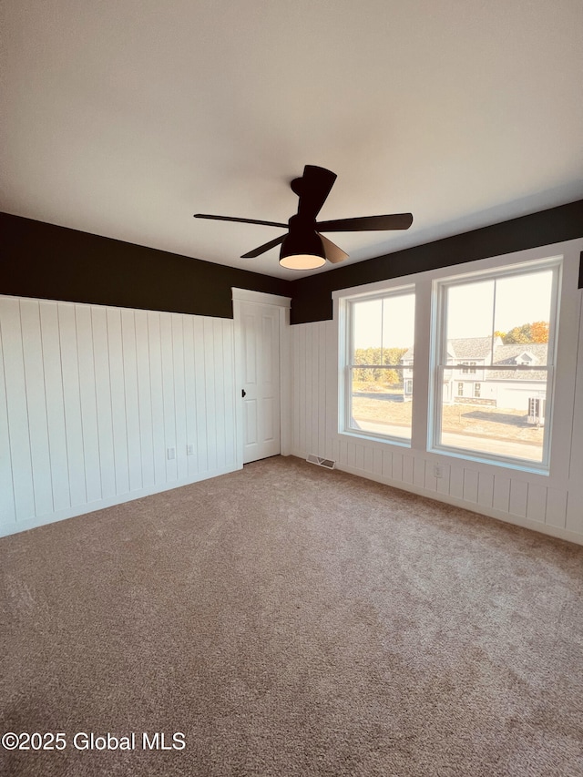 carpeted spare room with ceiling fan