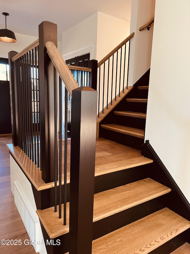 stairs featuring wood-type flooring