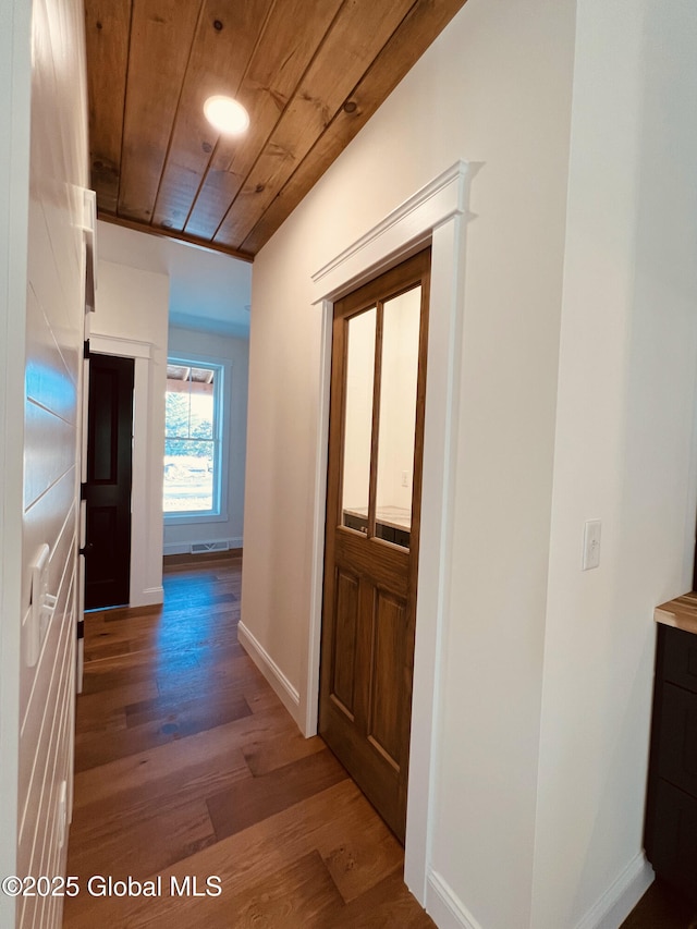 hall with dark hardwood / wood-style flooring and wood ceiling