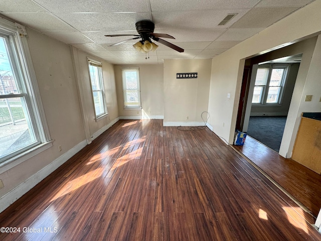 unfurnished room with a drop ceiling, ceiling fan, and dark hardwood / wood-style flooring