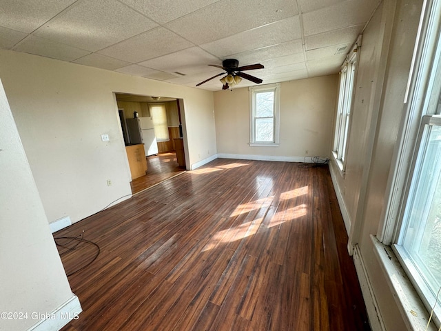 unfurnished room featuring ceiling fan, baseboard heating, a drop ceiling, and dark hardwood / wood-style floors