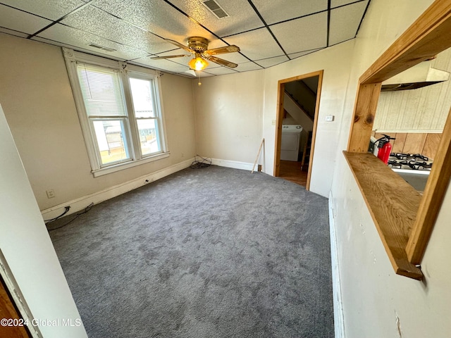 empty room with ceiling fan, carpet flooring, washer / dryer, and a paneled ceiling