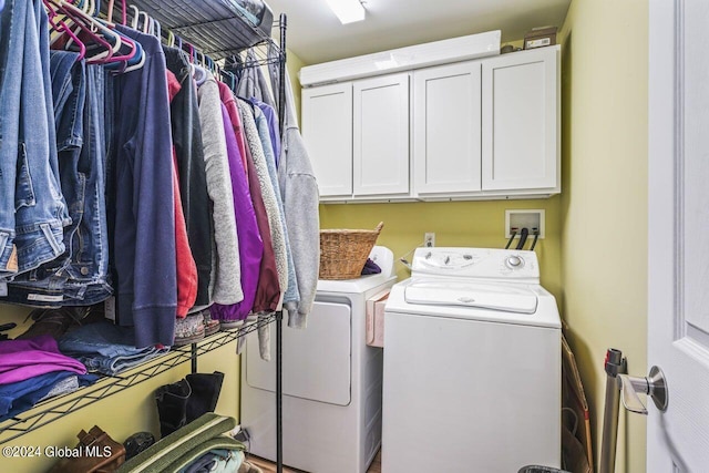 clothes washing area with washer hookup, cabinets, and washer and clothes dryer