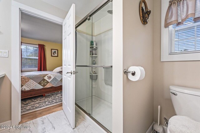 bathroom with toilet, hardwood / wood-style floors, and a shower with shower door