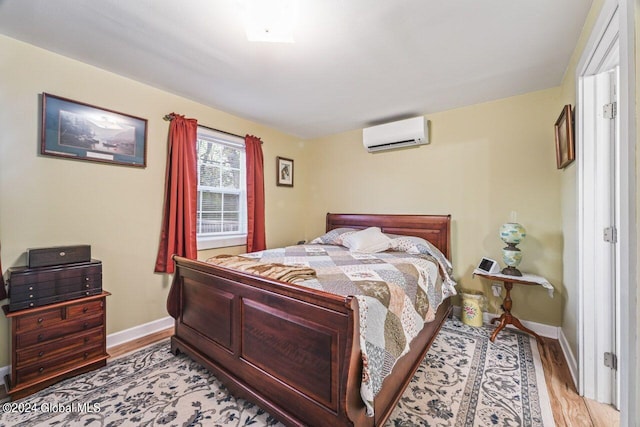 bedroom with light hardwood / wood-style floors and a wall mounted AC