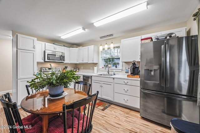 kitchen featuring refrigerator with ice dispenser, light hardwood / wood-style floors, pendant lighting, and white cabinetry