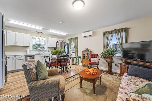 living room featuring sink, light wood-type flooring, and an AC wall unit