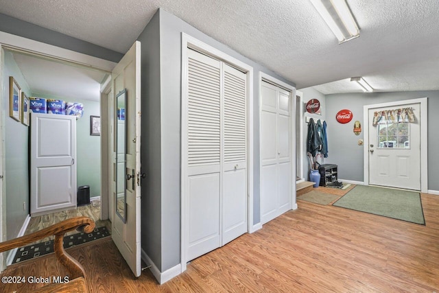 interior space featuring lofted ceiling, a textured ceiling, and light hardwood / wood-style floors