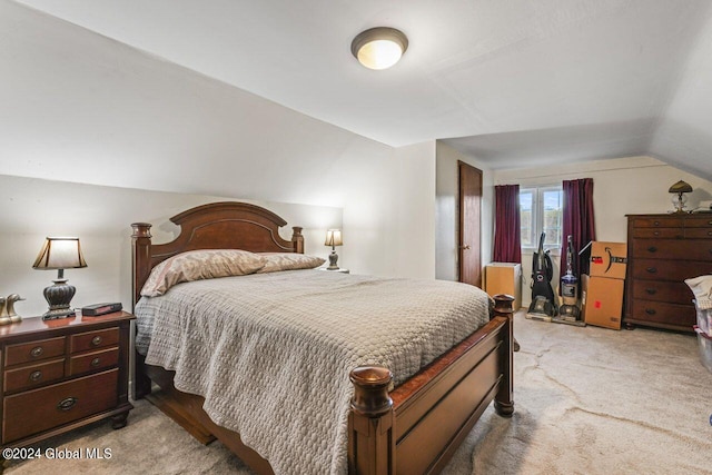 bedroom with lofted ceiling and light colored carpet