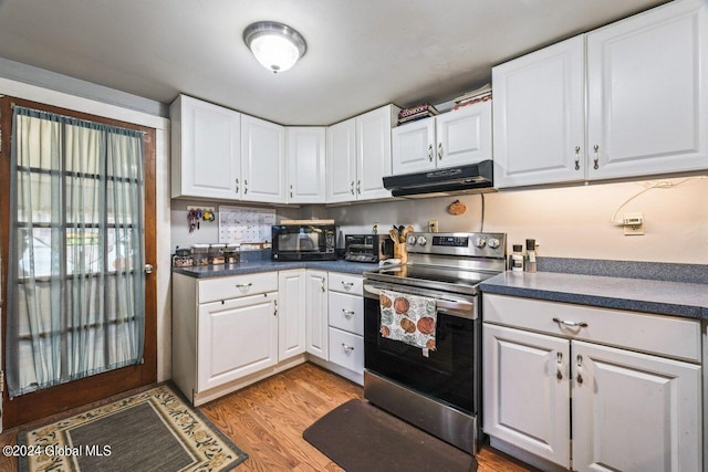 kitchen with electric stove, white cabinetry, and light hardwood / wood-style flooring