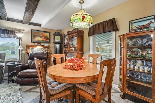 dining room with light hardwood / wood-style flooring and beamed ceiling