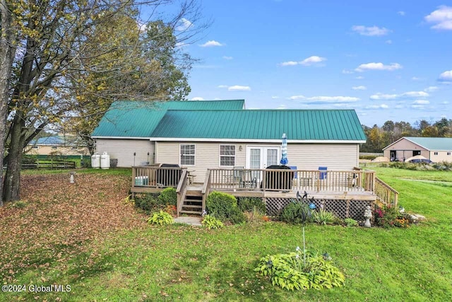 back of house featuring a lawn and a wooden deck