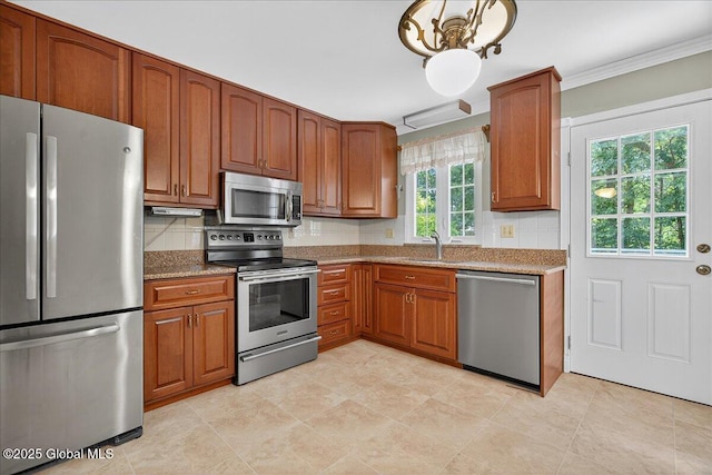 12 Lori Ln, Clifton Park, NY 12065 - kitchen featuring appliances with stainless steel finishes, crown molding, brown cabinetry, backsplash, and a chandelier