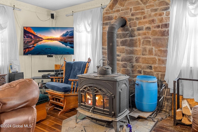 room details featuring hardwood / wood-style flooring, a wood stove, and ornamental molding