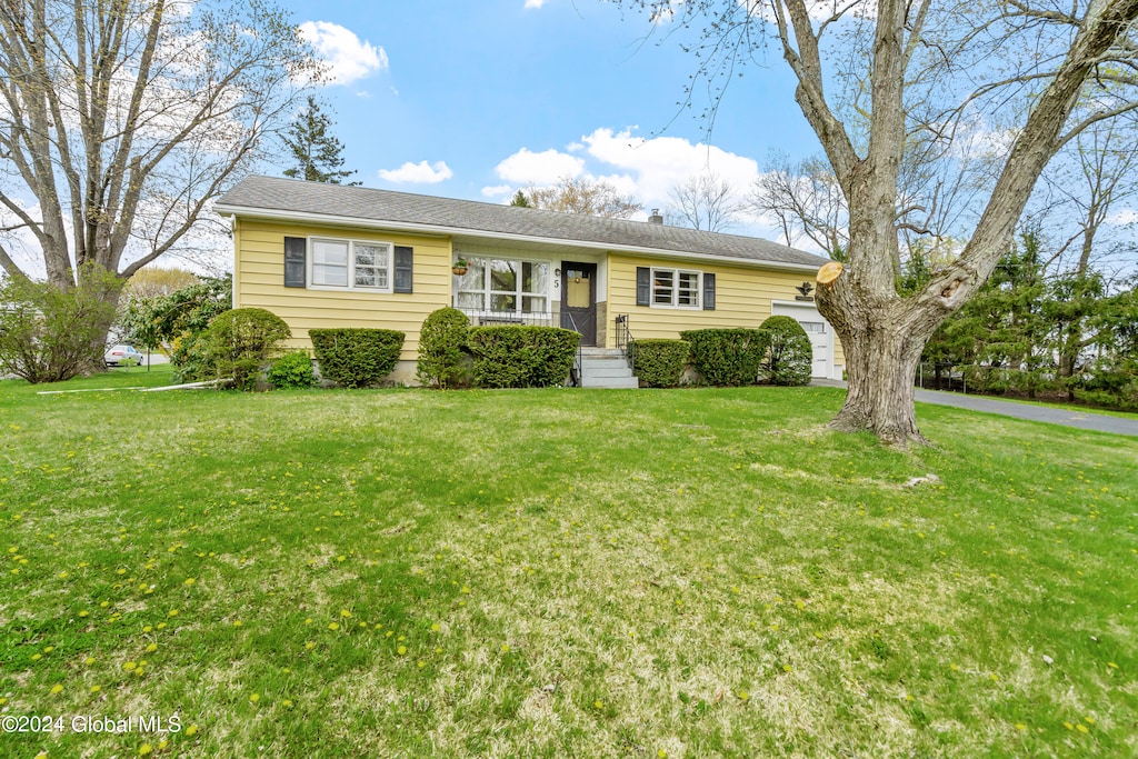 ranch-style house featuring a front lawn and a garage