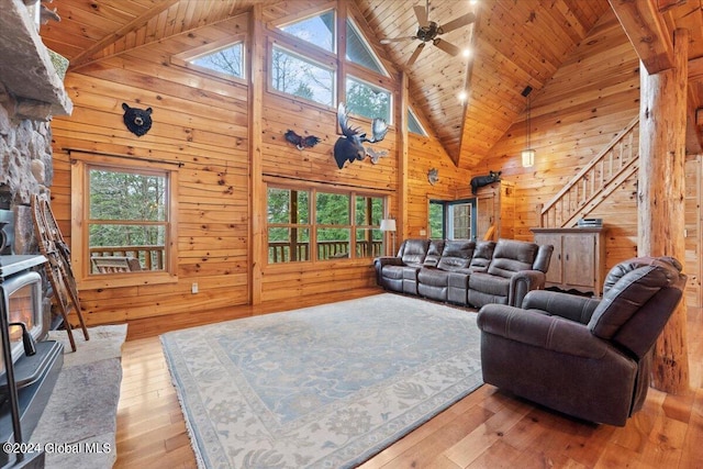 living room featuring wood walls, wood ceiling, high vaulted ceiling, and light hardwood / wood-style flooring