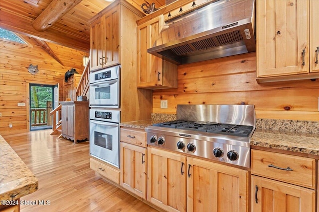 kitchen featuring wooden walls, light stone countertops, beamed ceiling, light hardwood / wood-style floors, and extractor fan