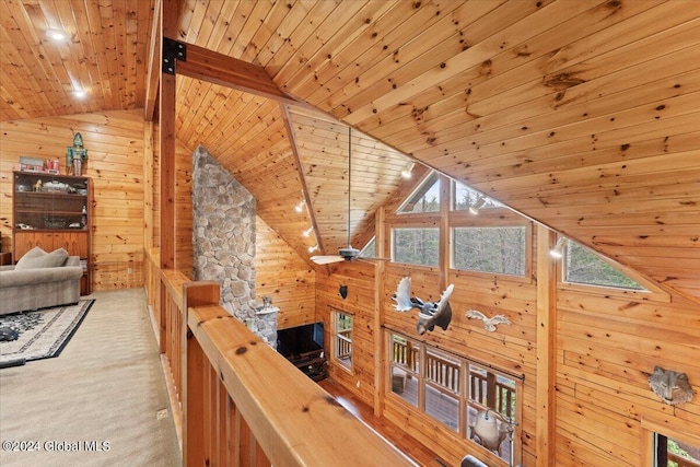 hall featuring wood walls, light colored carpet, and wooden ceiling