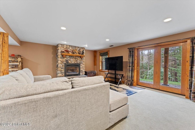 carpeted living room featuring a stone fireplace