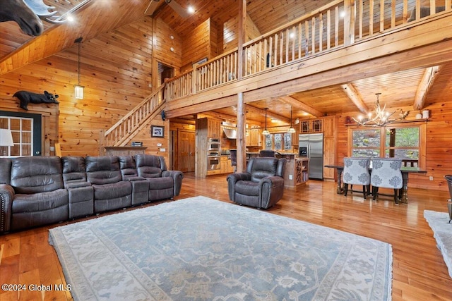 living room with wooden ceiling, high vaulted ceiling, a notable chandelier, wood-type flooring, and wooden walls