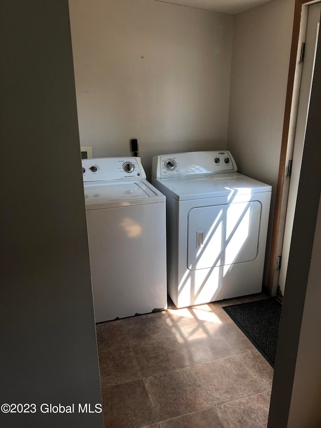 washroom with washing machine and clothes dryer and tile floors