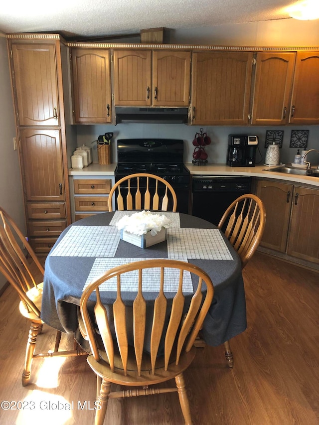 kitchen featuring exhaust hood, electric stove, black dishwasher, sink, and dark hardwood / wood-style flooring