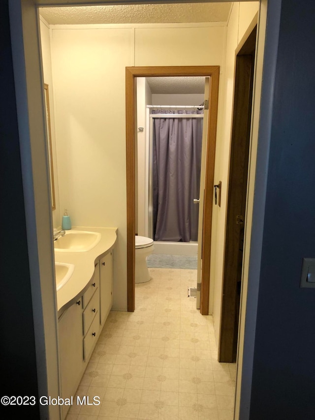 bathroom featuring dual bowl vanity, toilet, and tile flooring