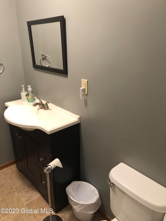 bathroom featuring toilet, tile flooring, and vanity