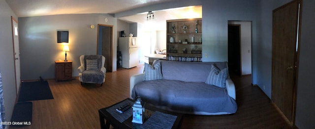 living room featuring vaulted ceiling and hardwood / wood-style flooring