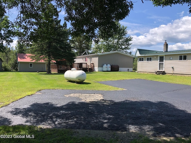 view of front of property featuring a front yard and a deck