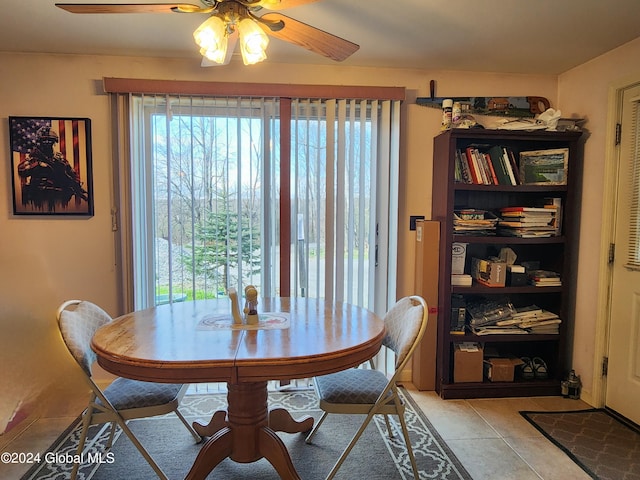 tiled dining space featuring plenty of natural light and ceiling fan