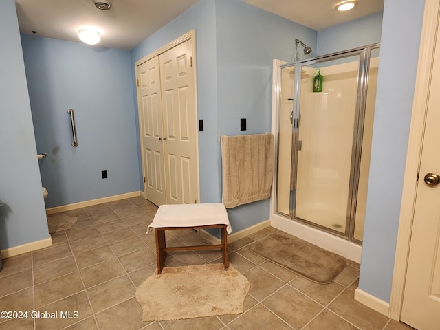 bathroom featuring a shower with shower door and tile flooring