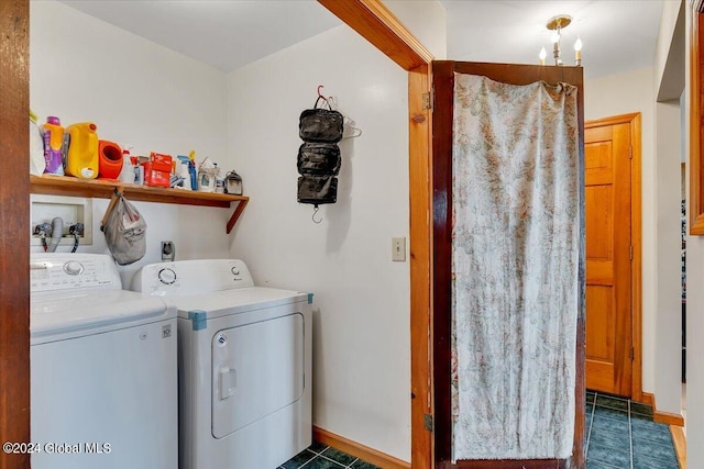 laundry area featuring washer and clothes dryer, a notable chandelier, and dark tile patterned flooring