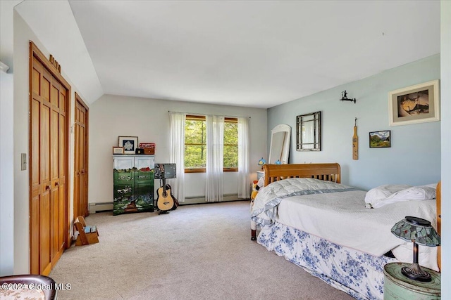 carpeted bedroom with vaulted ceiling, a baseboard heating unit, and a closet