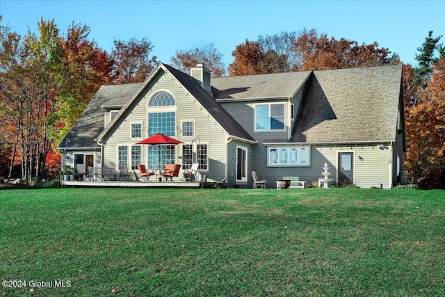 rear view of property with a yard and a deck