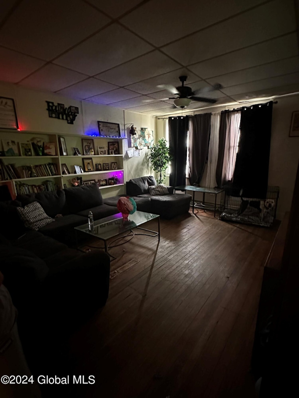 living room featuring wood-type flooring, a paneled ceiling, and ceiling fan