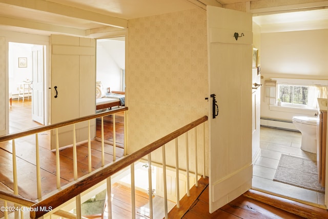 staircase featuring a baseboard heating unit