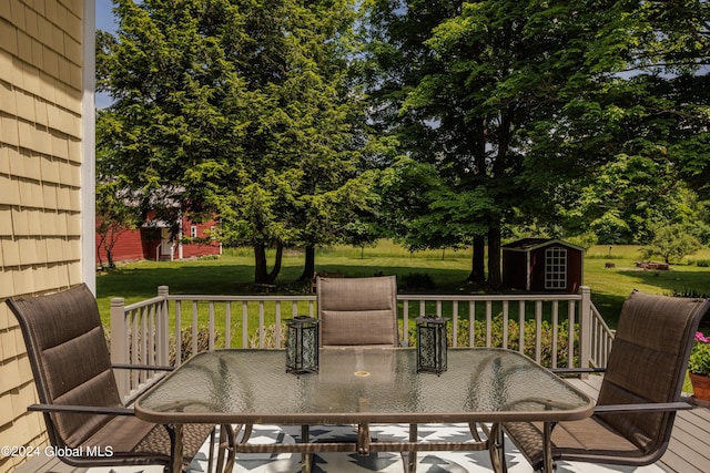 wooden deck with a storage unit and a yard