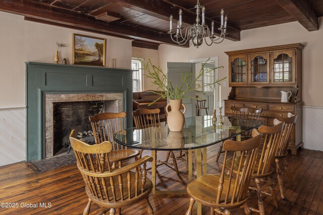 dining area with wooden ceiling, hardwood / wood-style floors, an inviting chandelier, and beamed ceiling